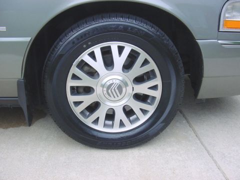 2003 Mercury Grand Marquis - Front wheel and fender detail of a 2003 Mercury Grand Marquis.