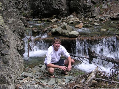 1986 Ford Bronco - Man poses by a waterfall in a natural outdoor setting.