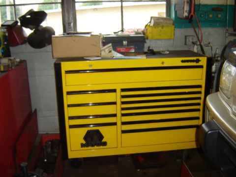 1992 Ford Bronco - A yellow tool chest sits in a garage next to a silver vehicle.