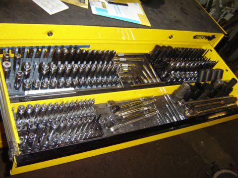 1992 Ford Bronco - A yellow toolbox drawer is filled with neatly arranged sockets and wrenches, a well-organized collection of tools.