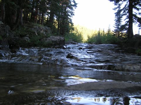 1986 Ford Bronco - A natural scene of a river flowing over rocks with trees in the background.