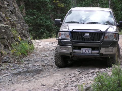 1986 Ford Bronco - This Ford F-150 is navigating a challenging, rocky mountain trail.