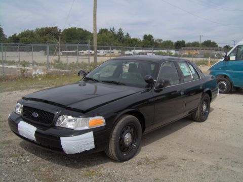 2000 Ford Crown Victoria - Black 2000 Ford Crown Victoria with its hood open and front bumper taped, seen from a 3/4 front angle.
