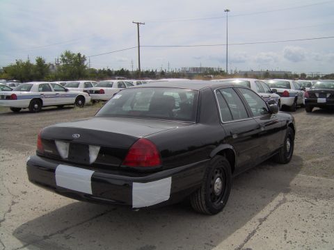 2000 Ford Crown Victoria - Rear view of a black 2000 Ford Crown Victoria police car in an outdoor lot.