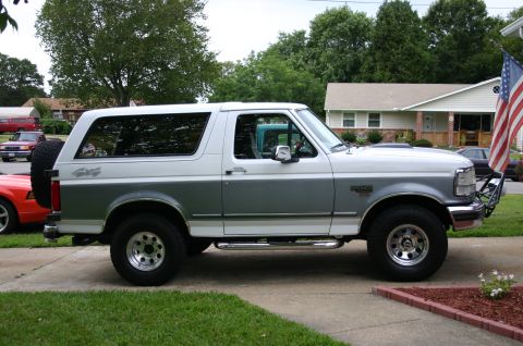 1994 Ford Bronco - This 1994 Ford Bronco is shown in a side profile, its distinctive two-tone paint scheme and 4x4 badging.