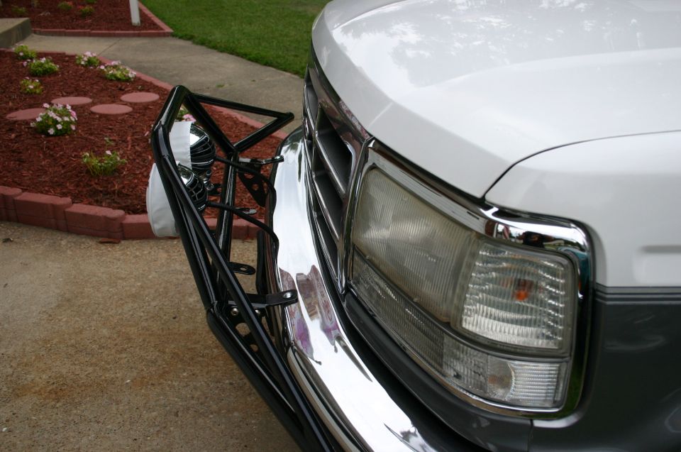 White Ford truck front corner with chrome bumper and black tube light bar bracket
