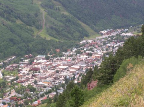 1986 Ford Bronco - A wide shot captures a town situated within a lush, green mountain landscape.