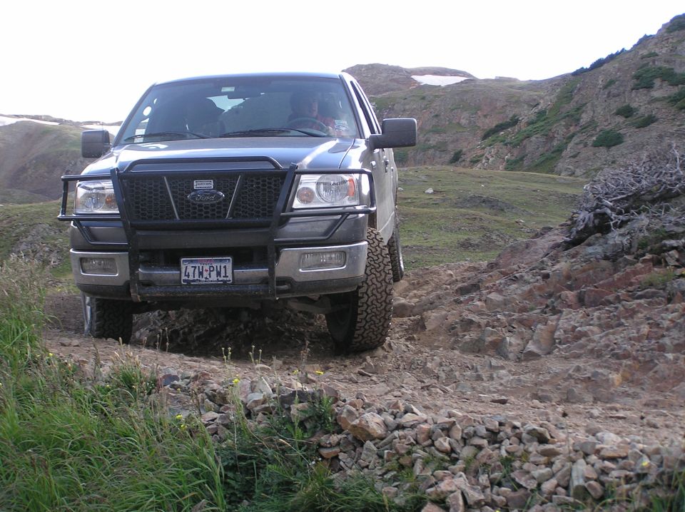 Ford F-150 pickup truck with bull bar driving on rocky terrain