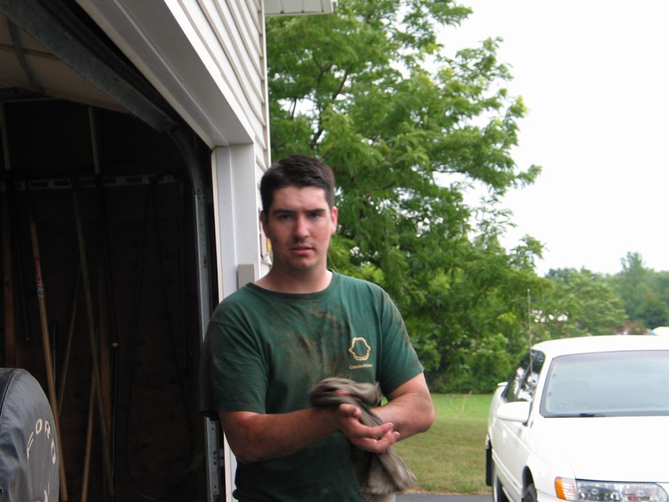 Man holding a rag in front of an open garage door