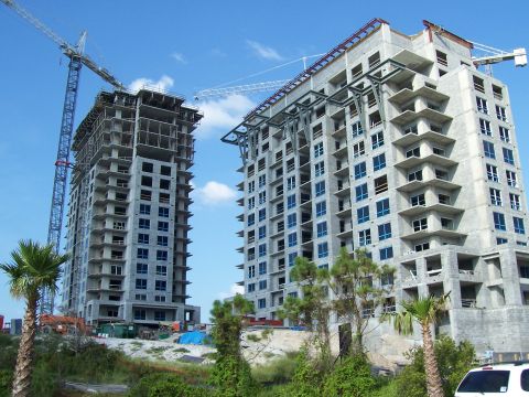1995 Ford Bronco - Two tall buildings are under construction, with cranes visible against a bright blue sky.