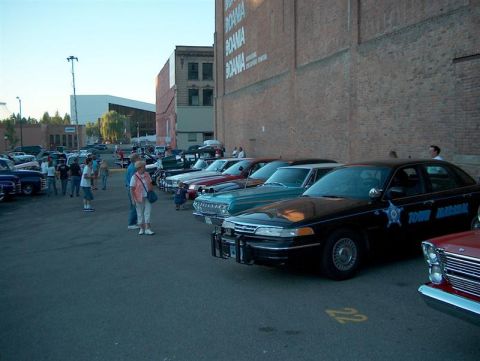 2001 Ford Crown Victoria - A black 2001 Ford Crown Victoria police car is parked in a lot with other vehicles.