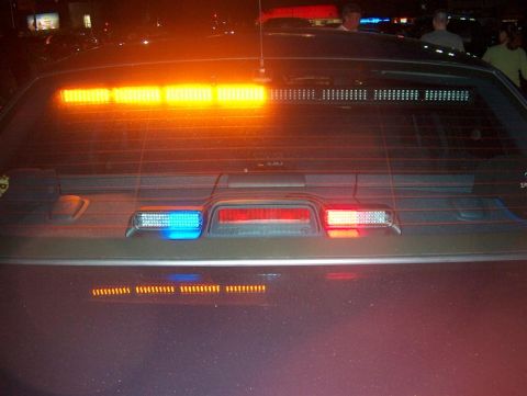 2001 Ford Crown Victoria - Rear view of a vehicle equipped with emergency lights, including a light bar across the rear window.