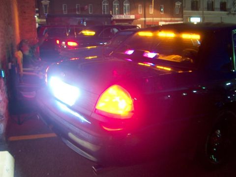 2001 Ford Crown Victoria - A 2001 Ford Crown Victoria police car is seen from the front, its emergency lights illuminated.
