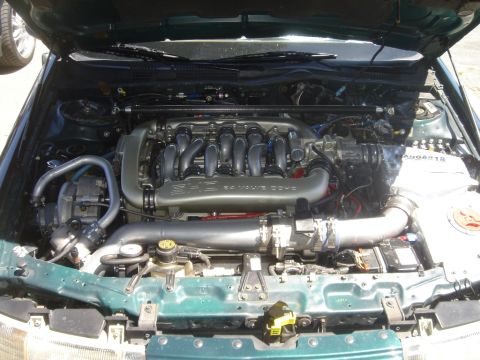1991 Ford Taurus - Engine bay of a car, showing the V6 engine and associated components. The hood is open, revealing the engine's details.