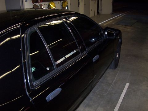 2003 Ford Crown Victoria - A black 2003 Ford Crown Victoria sedan is parked indoors, showing its side profile.