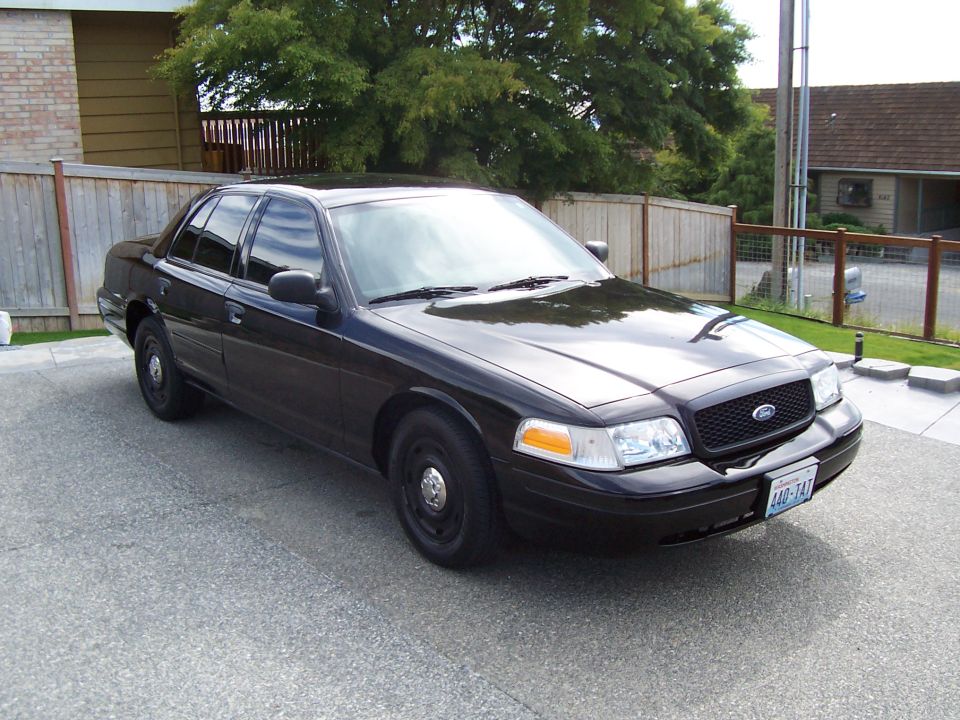 Black 2003 Ford Crown Victoria sedan parked on asphalt, front quarter view