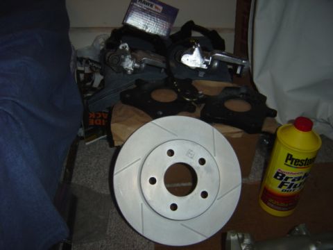 1998 Ford Taurus - Collection of brake components including rotors, calipers, and fluid, likely for a vehicle repair or upgrade.