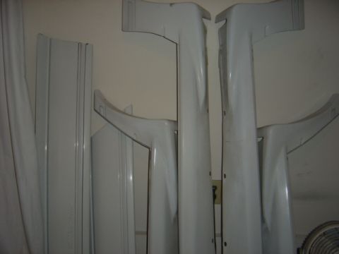 1998 Ford Taurus - Various white car body kit components are stored indoors.