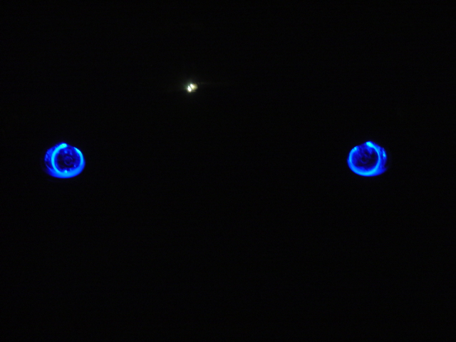 Two blue glowing rings on black background, possibly headlights