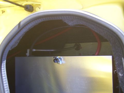 2002 Ford Mustang - The interior of a car's trunk reveals electrical wiring and a metallic component, with a website logo visible.