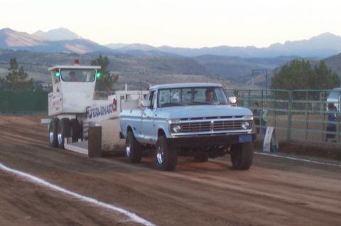 1994 Ford F-150 - Pickup truck and trailer on a dirt track with mountains in the background.