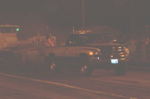 1994 Ford F-150 - Pickup truck with American flag is seen driving at night, with a trailer behind it.