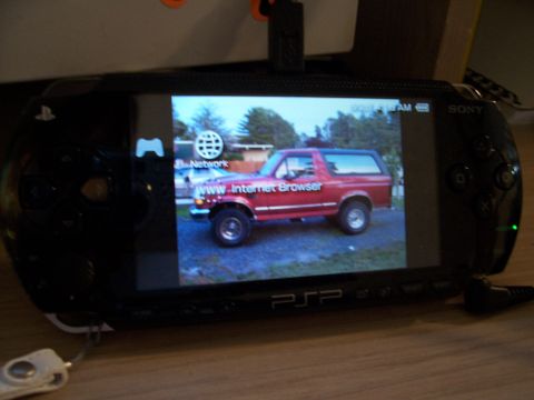 1995 Ford Bronco - A red 1995 Ford Bronco is shown on the screen of a PSP handheld gaming device.