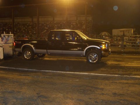 1994 Ford F-150 - A dark-colored Ford F-250 Super Duty truck is seen in profile at an outdoor event at night.