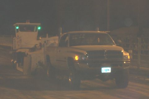 1994 Ford F-150 - A Dodge Ram pickup truck tows a trailer with a cab, with "2002 AD 02" visible on the windshield.