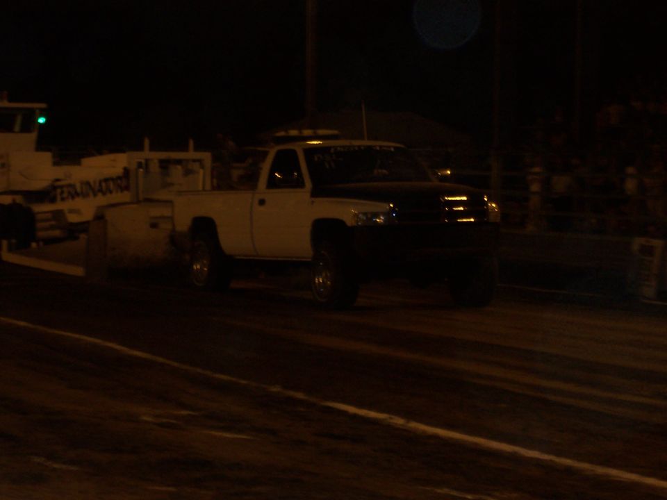 White and black pickup truck with a trailer labeled "TERMINATOR"