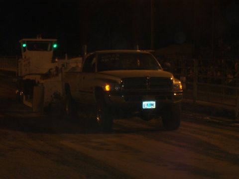 1994 Ford F-150 - A Dodge Ram pickup truck is seen at night, with a tow vehicle behind it. The license plate is visible.