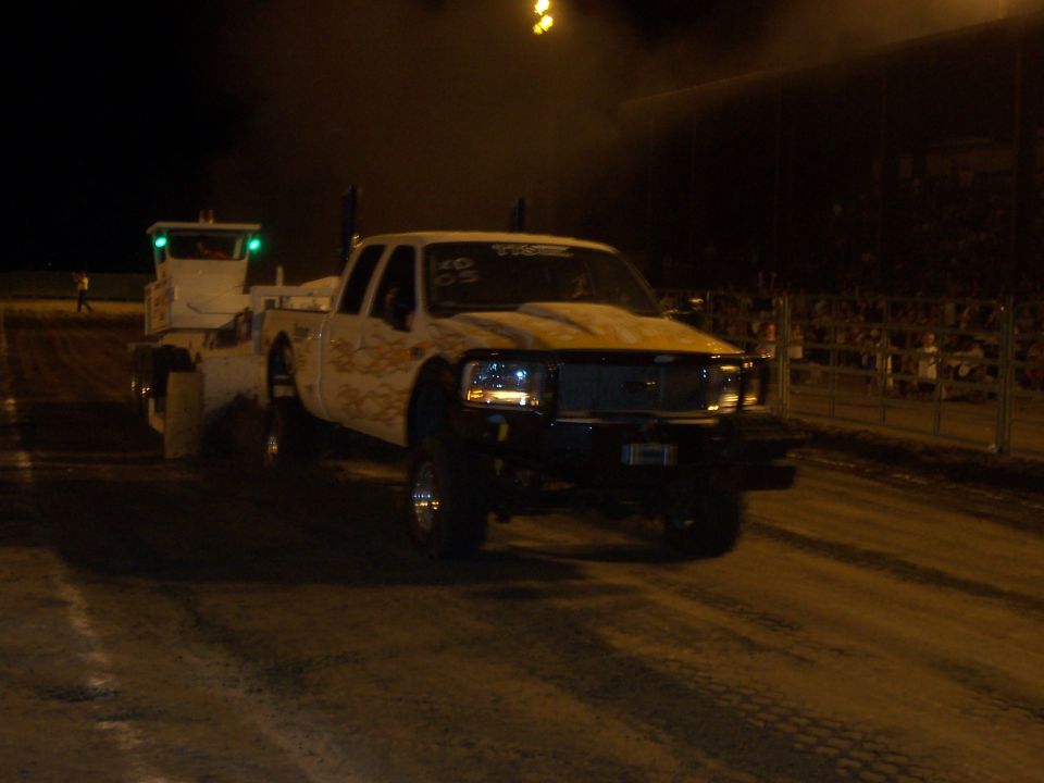 Pickup truck with a lifted suspension and aftermarket hood, possibly at a drag strip