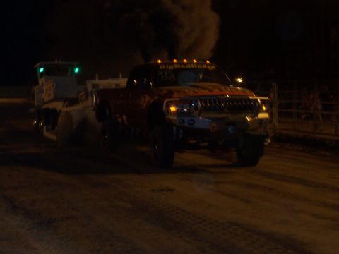 1994 Ford F-150 - A red pickup truck, identified as "BigBadDodge", emits black smoke while towing a trailer in the dark.