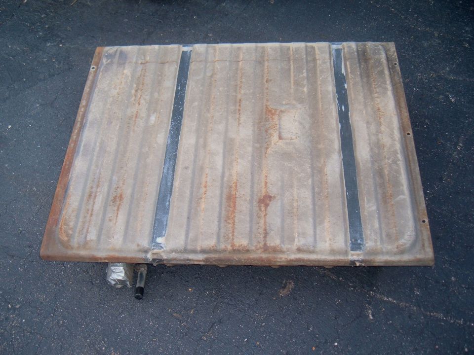 metal fuel tank with ribbed surface and two dark straps