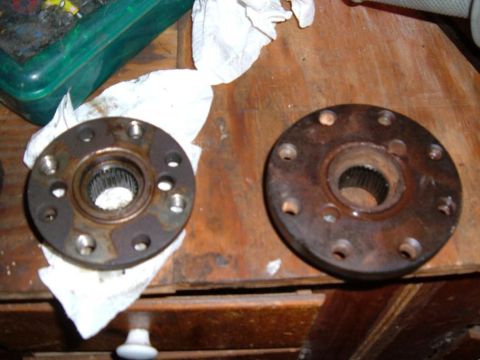 1985 Ford Ranger - Two rusty wheel hubs, likely for a truck or SUV, are shown on a wooden workbench.