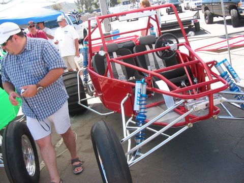 1986 Ford Bronco - Custom red sand rail buggy with four seats and prominent suspension components.