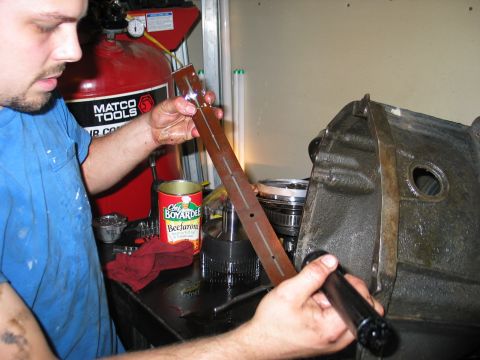 1995 Ford Bronco - A mechanic inspects a transmission dipstick next to a large transmission housing, with a can of Chef Boyardee in the background.