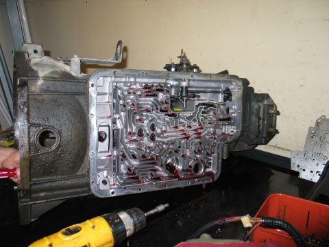1995 Ford Bronco - Automatic transmission valve body disassembled for service. A drill is visible in the foreground.
