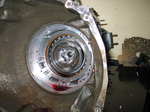 1995 Ford Bronco - The internal workings of a transmission are exposed, showing the torque converter and surrounding metal housing.
