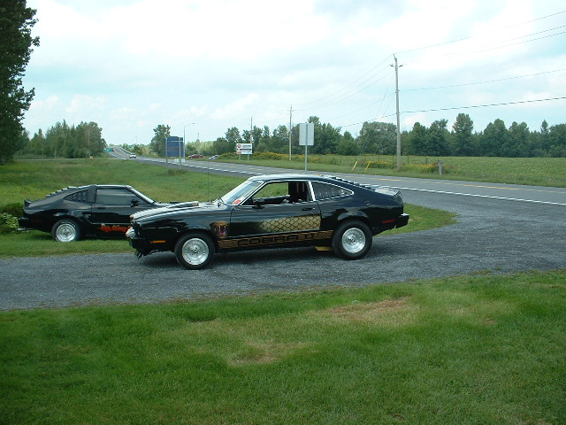 Black 1978 Ford Mustang II Cobra parked on gravel with another Mustang II behind it