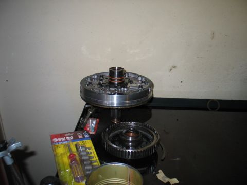 1995 Ford Bronco - Transmission pump assembly disassembled on a workbench with a set of tools.