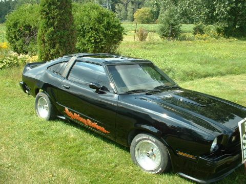 1978 Ford Mustang II - This black coupe features a distinctive louvered rear window and custom graphics on its side.