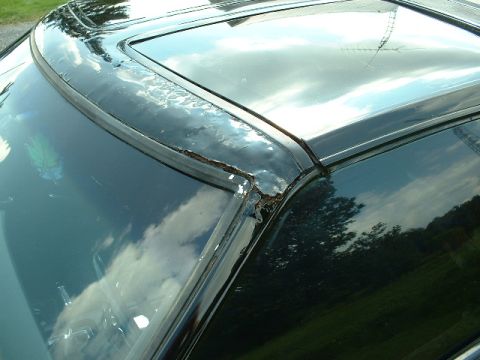 1978 Ford Mustang II - Close-up view of a car's roofline and windshield frame, revealing significant rust and paint damage.