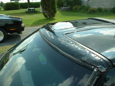 1978 Ford Mustang II - Close-up of a black car's roof and sunroof, with another vehicle partially visible in the background.