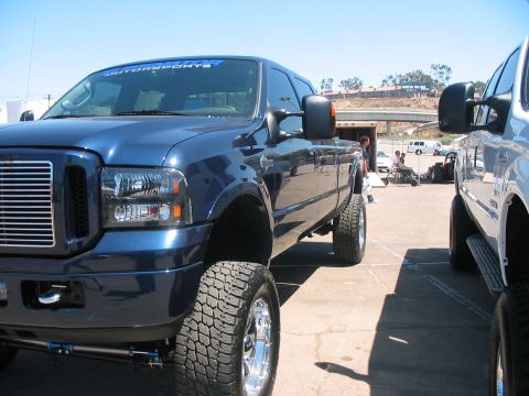 1986 Ford Bronco - Blue Ford F-250 Super Duty truck, likely from the mid-2000s, is parked next to another vehicle.