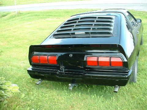 1978 Ford Mustang II - This black coupe features distinctive horizontal louvers over the rear window and triple stacked taillights.