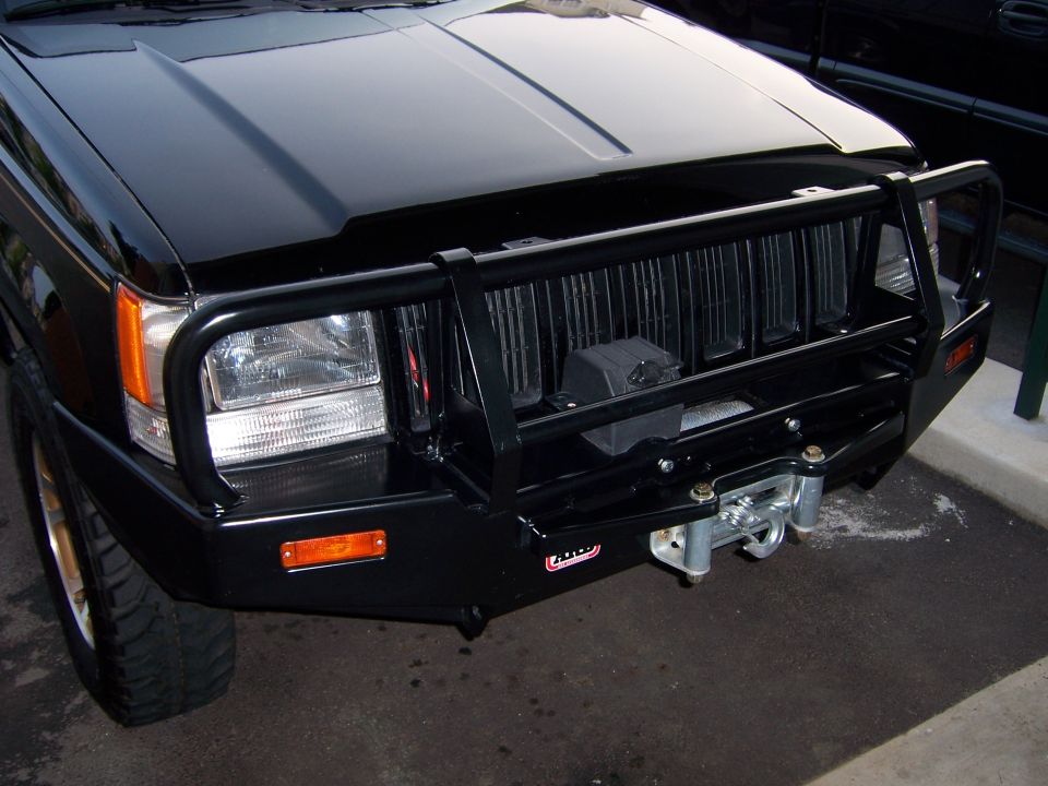 Front view of a black 1996 Jeep Grand Cherokee with a heavy-duty bull bar and winch installed