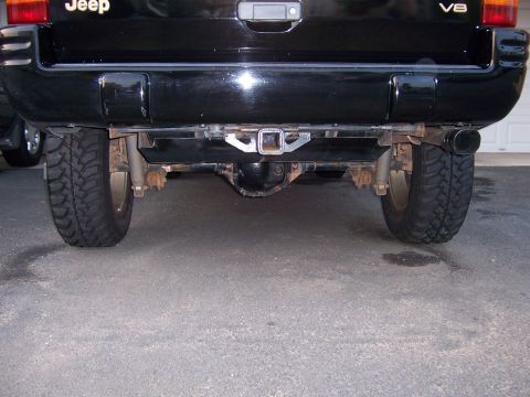 1996 Jeep Grand Cherokee - Rear view of a black 1996 Jeep Grand Cherokee, showing the trailer hitch and V8 badging.