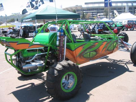1986 Ford Bronco - A custom-built dune buggy with vibrant green and orange graphics is displayed at an outdoor event.