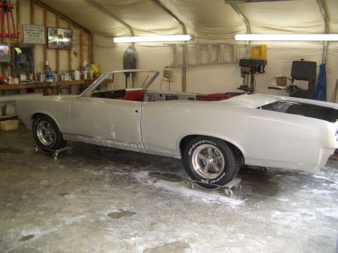 1967 Pontiac GTO - A 1967 Pontiac GTO convertible is shown in a garage, appearing to be in the process of restoration.